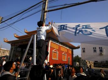 与政府达成协议之后的乌坎村民拆下横幅标语，2011年12月21日。